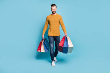 Full size photo of young smiling positive cheerful handsome man go walk after shopping isolated on...
