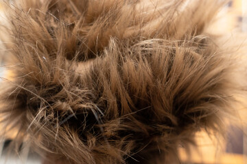 a piece of brown, artificial fur on a light background. The texture of artificial materials. Allergy, an alternative to natural fur. Animal protection