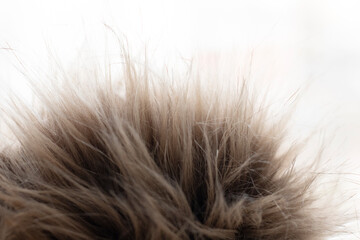 a piece of brown, artificial fur on a light background. The texture of artificial materials. Allergy, an alternative to natural fur. Animal protection
