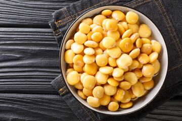 Traditional appetizer lupine beans close-up in a bowl on the table. horizontal top view from above