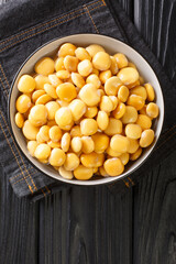Delicious Mediterranean lupine beans close-up in a bowl on the table. Vertical top view from above