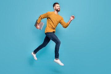 Fototapeta na wymiar Full length body size view of nice cheerful motivated guy jumping running carrying laptop isolated on bright blue color background