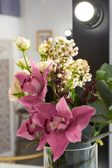 A bouquet of lily flowers stands on a table with a make-up mirror