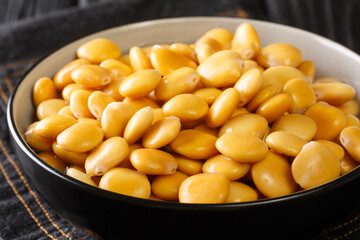 Traditional appetizer lupine beans close-up in a bowl on the table. horizontal
