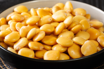Salted yellow lupine beans close-up in a bowl on the table. horizontal