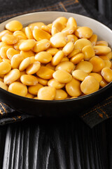Delicious Mediterranean lupine beans close-up in a bowl on the table. Vertical