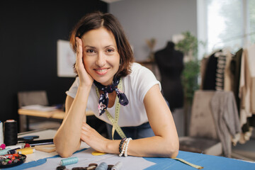 A Positive woman posing at sewing studio