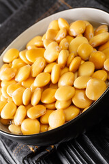 Pickled lupine beans close-up in a bowl on the table. Vertical