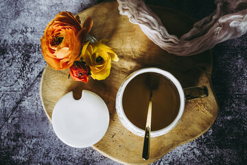 Mug avec du thé sur la table avec un bouquet de fleurs renoncules colorées