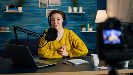 Blogger speaking about life during podcast in home studio looking at camera. Online show On-air...