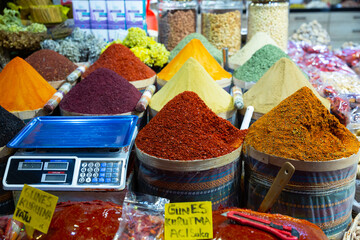 Colorful market counter offering for sale variety of natural spices and herbs, price tags in Turkish