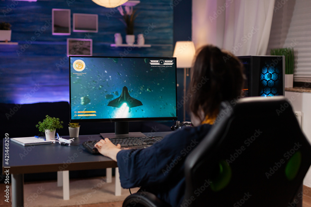 Poster focused player sitting on gaming chair in home studio and playing online videogames using rgb keywor