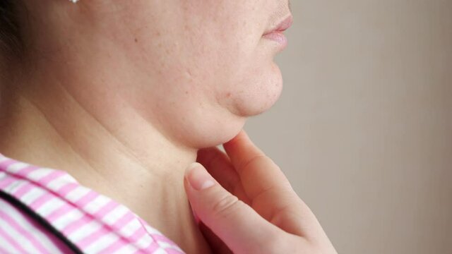 Unrecognizable woman touches double chin.