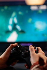 Close up of wireless joystick, gamer playing online videogames for live gamers tournament. Professional pro player streaming online video game new graphics using powerful computer.