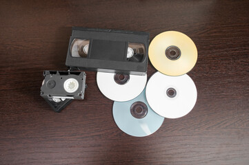 videotape and cd on brown wooden background