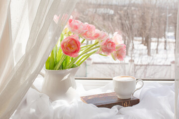 still life a vase with tulips and an old book on the window