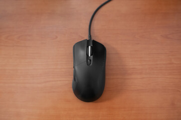 Black wired gaming mouse on wooden table