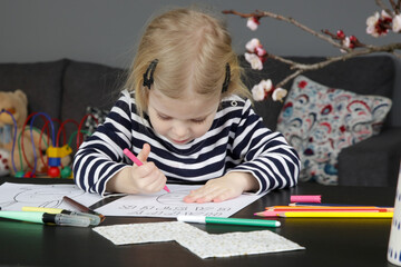Adorable little girl coloring picture for Easter at home