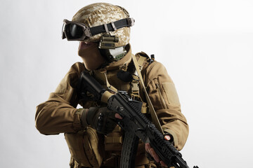 Male soldier in tactical equipment and uniform (coyote brown color) . Shot in studio on a white...