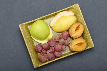 fresh fruits grape, plum, apple, pear in the plate