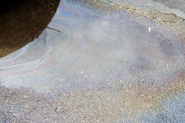 Stream of rainwater and oil products on the asphalt.