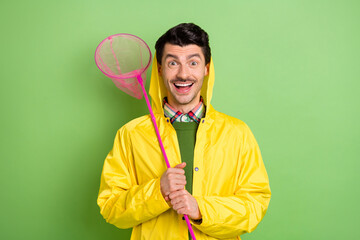 Photo of brunet impressed guy hold net wear cloak isolated on green color background