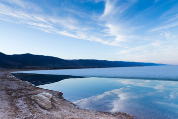 Morning landscape of lake Baikal with reflaction of blue sky in pure water.