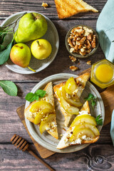 Summer healthy breakfast or snack, antipasto. Grill toast with caramelized pear, honey, nuts and cheese ricotta on a wooden rustic table. Top view flat lay.
