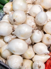 Fresh white onions in the store. Crates full of ripe onions for sale at a grocery store counter.