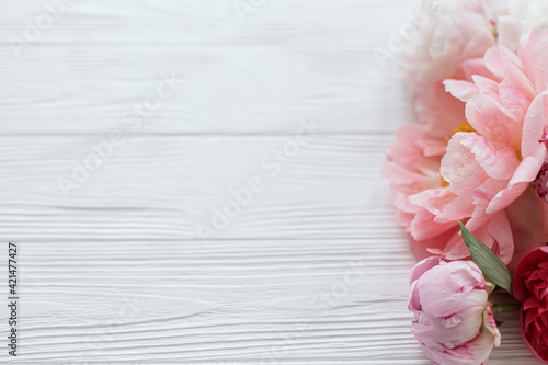 Beautiful tender peony border on white wood with copy space. Floral greeting card. Happy Mothers day