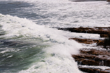 big waves crashing against rocky shoreline in Tasmania, Australia