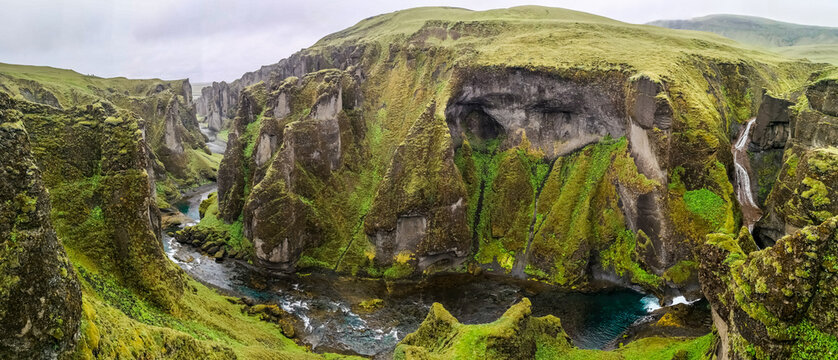Majestic Fja&eth;r&aacute;rglj&uacute;fur, Canyon Fardrargljufur Island Iceland during a rainy and wet days. Canyon with green flora and blue water in tranquility.