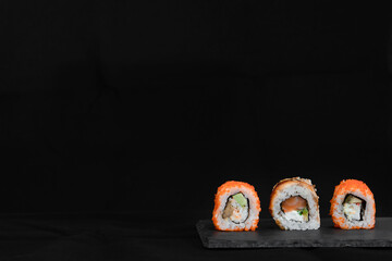 Close up of sushi roll set on tray on black background 