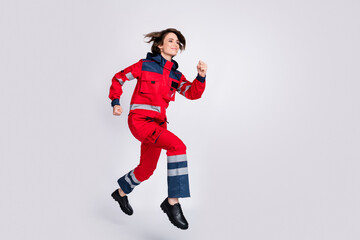 Full size profile side photo of happy good mood woman paramedic running to help isolated on grey color background