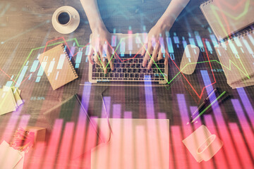 Multi exposure of woman hands working on computer and forex chart hologram drawing. Top View. Financial analysis concept.