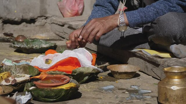 Close up of male hindu sitting on the floor offering water to Gods in hindu puya.