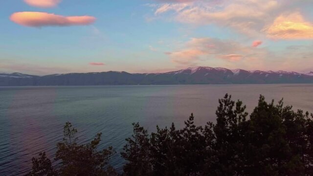Freshwater mountains lake Sevan and beautiful sky heaven during sunset aerial drone fly over footage.