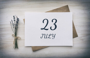 july 23. 23th day of the month, calendar date.White blank of paper with a brown envelope, dry bouquet of lavender flowers on a wooden background. Summer month, day of the year concept