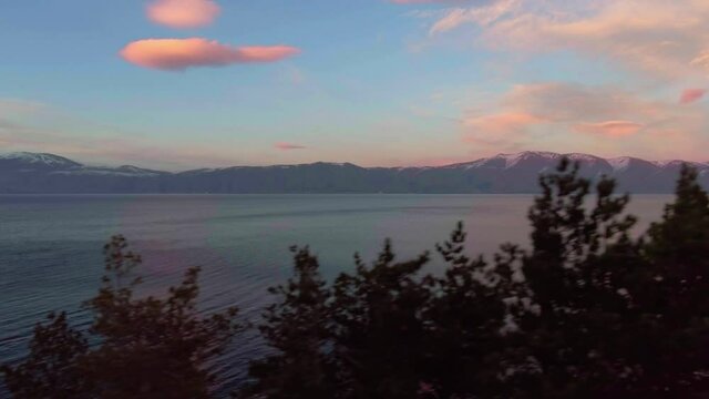 Freshwater mountains lake Sevan and beautiful sky heaven during sunset aerial drone fly over footage.