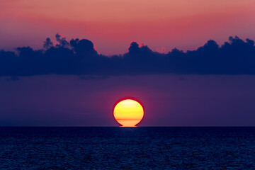 colori al tramonto 02 - sole all'orizzonte con nubi scure e colori caldi