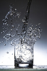 Wasser in Glas einschenken mit Spritzer