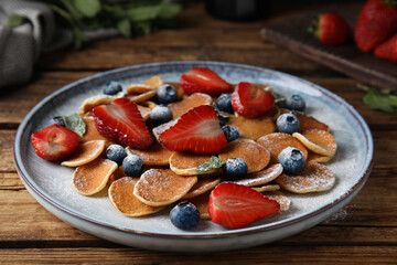Cereal pancakes with berries on wooden table