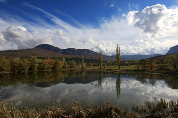 Fototapeta na wymiar Beautiful autumn landscape in a mountain valley of Crimea with reflection of trees and mountains in the water of the lake