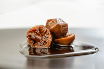 walnut jam isolated, o a black plate, close up