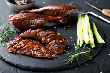 Peking duck with sauce on a dark table