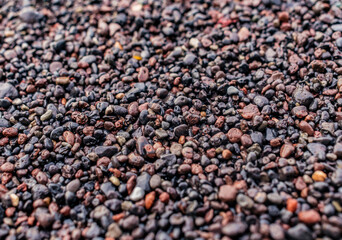 Selective focus on wet black and volcanic sand from São Miguel island, texture with blur