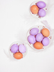 Colored eggs on plate with on white background. Flat lay. Copy space.  Easter concept. Top view.