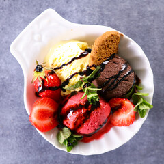 bowl of ice cream with strawberry and biscuit