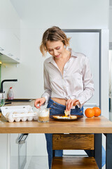 Woman  dips toast in fried egg