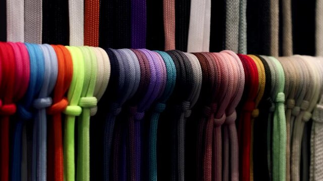 different colors of laces or rope on the shelves of a clothing factory